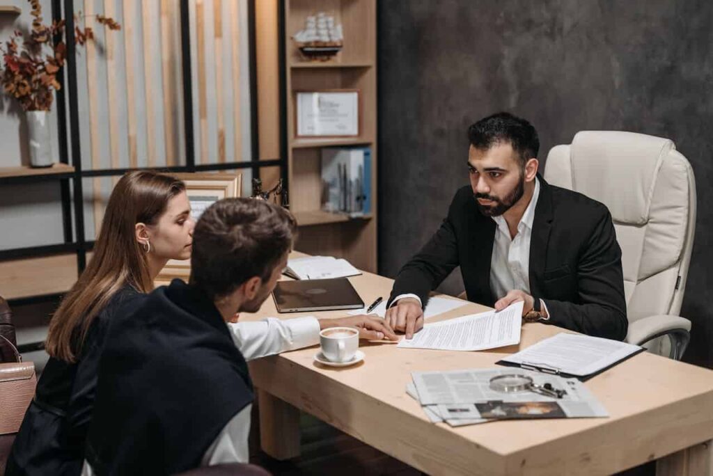 a-man-in-black-suit-talking-to-his-clients