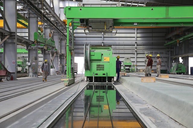 people-stands-near-green-metal-industrial-machine